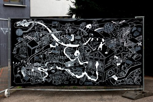 A large drawing is stretched out on a construction fence.