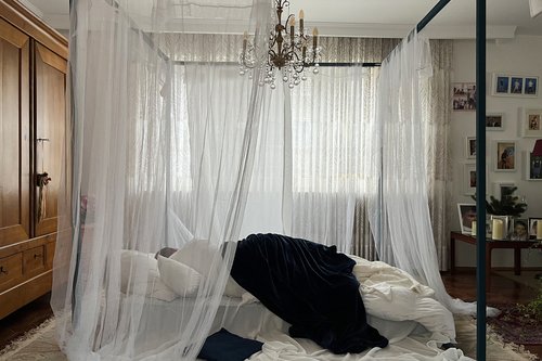 A bed stands in the centre of the room.