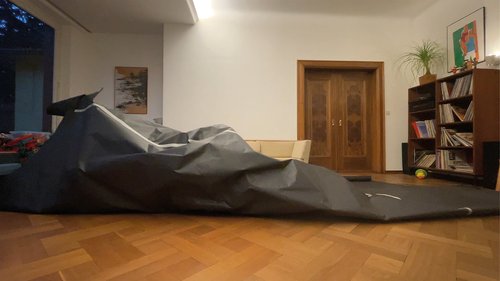 A spatial sculpture made of black paper in a living room.
