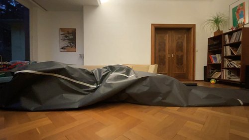 A spatial sculpture made of black paper in a living room.