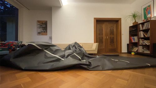 A spatial sculpture made of black paper in a living room.
